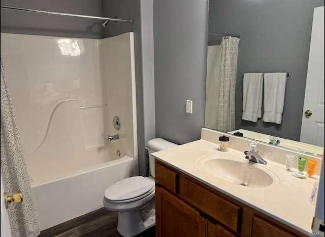 full bathroom with hardwood / wood-style flooring, toilet, vanity, and shower / bath combo with shower curtain