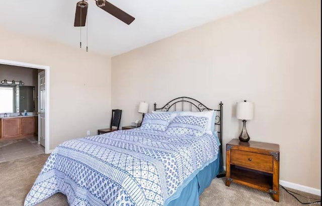 carpeted bedroom with ensuite bath and ceiling fan