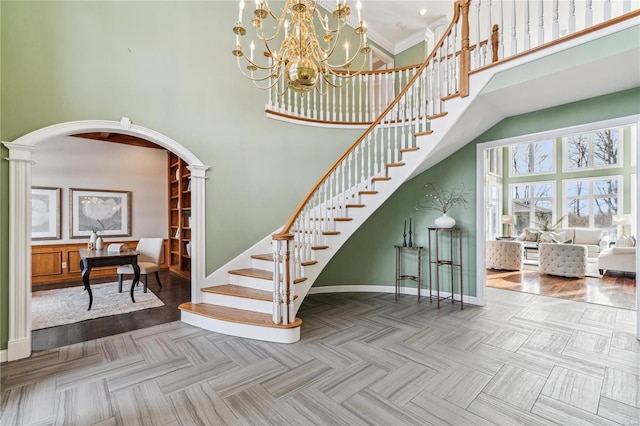 staircase with crown molding and a high ceiling