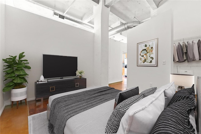 bedroom with hardwood / wood-style flooring and a high ceiling