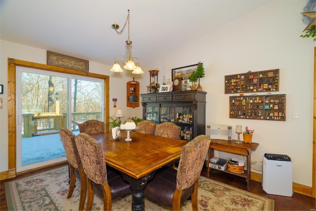 dining space featuring a notable chandelier, hardwood / wood-style flooring, and vaulted ceiling