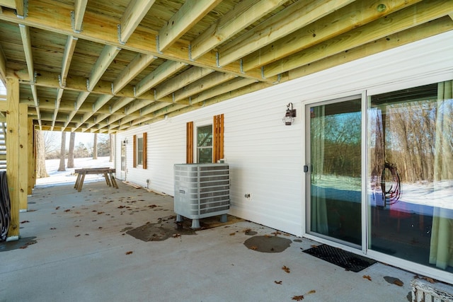 snow covered patio featuring central AC unit