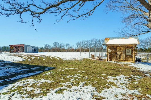 yard layered in snow featuring an outbuilding