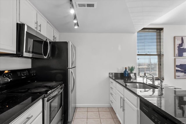 kitchen featuring white cabinetry, appliances with stainless steel finishes, sink, and dark stone counters