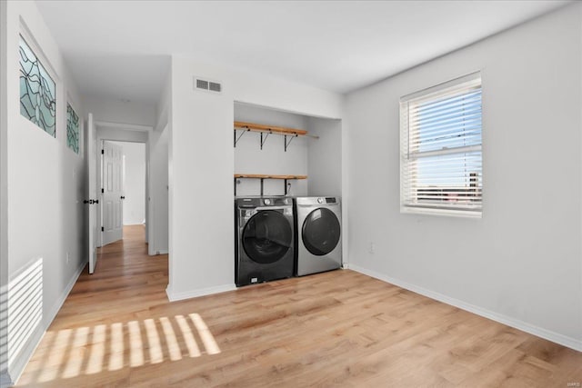 laundry area featuring independent washer and dryer and light wood-type flooring