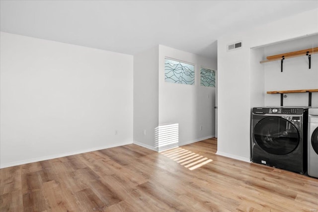 laundry room featuring washing machine and dryer and light wood-type flooring