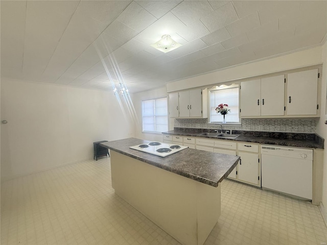 kitchen with sink, a kitchen island, white cabinetry, and white appliances