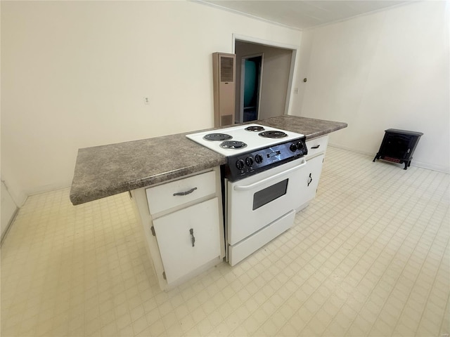 kitchen featuring a kitchen bar, white cabinetry, and white electric range