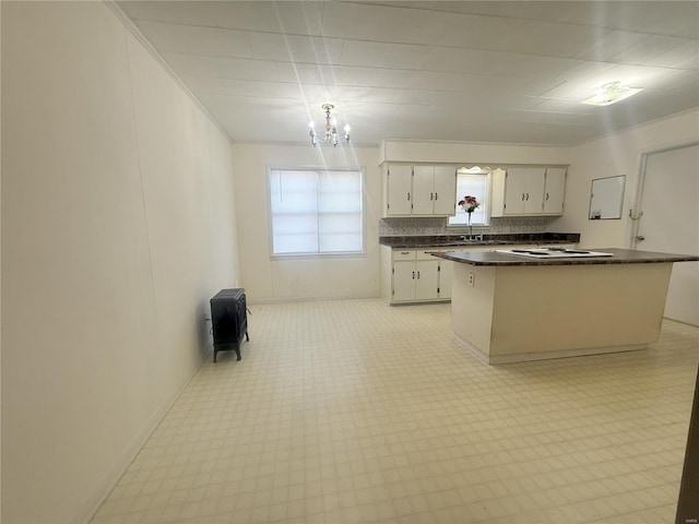 kitchen with sink, white cabinets, a center island, and a chandelier