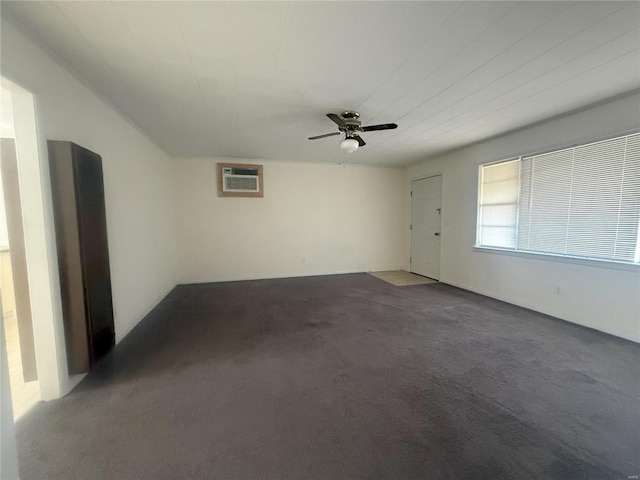 empty room with carpet flooring, an AC wall unit, and ceiling fan