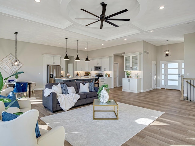 living room featuring coffered ceiling, a high ceiling, and light wood-type flooring