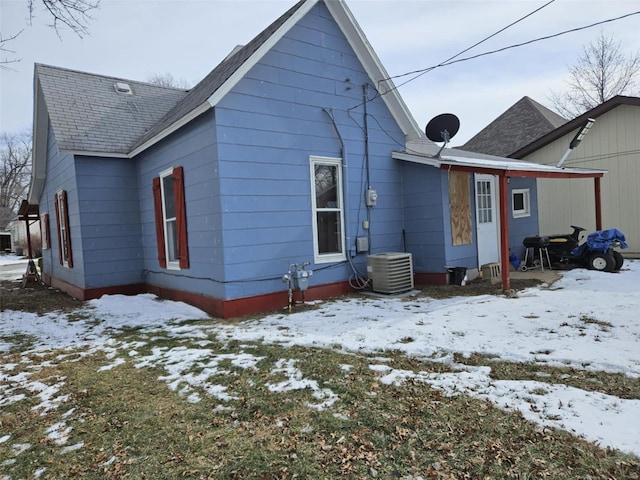 snow covered back of property with central air condition unit