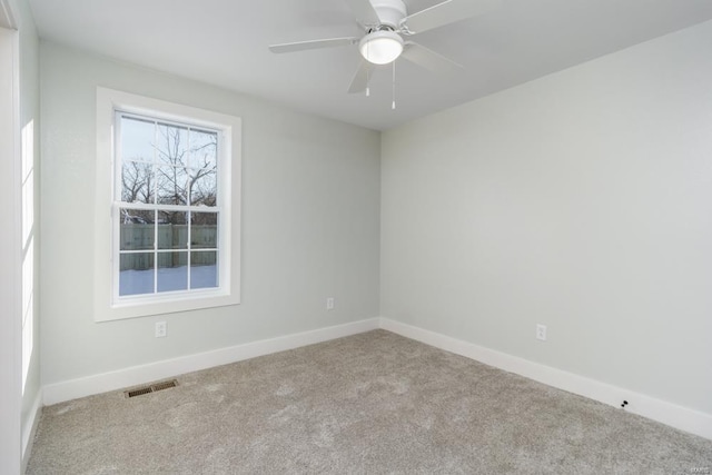 empty room featuring ceiling fan and light colored carpet