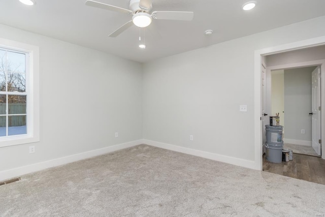 empty room featuring ceiling fan and carpet