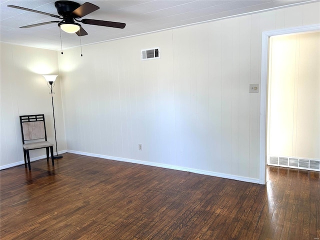 empty room with ceiling fan and dark hardwood / wood-style flooring