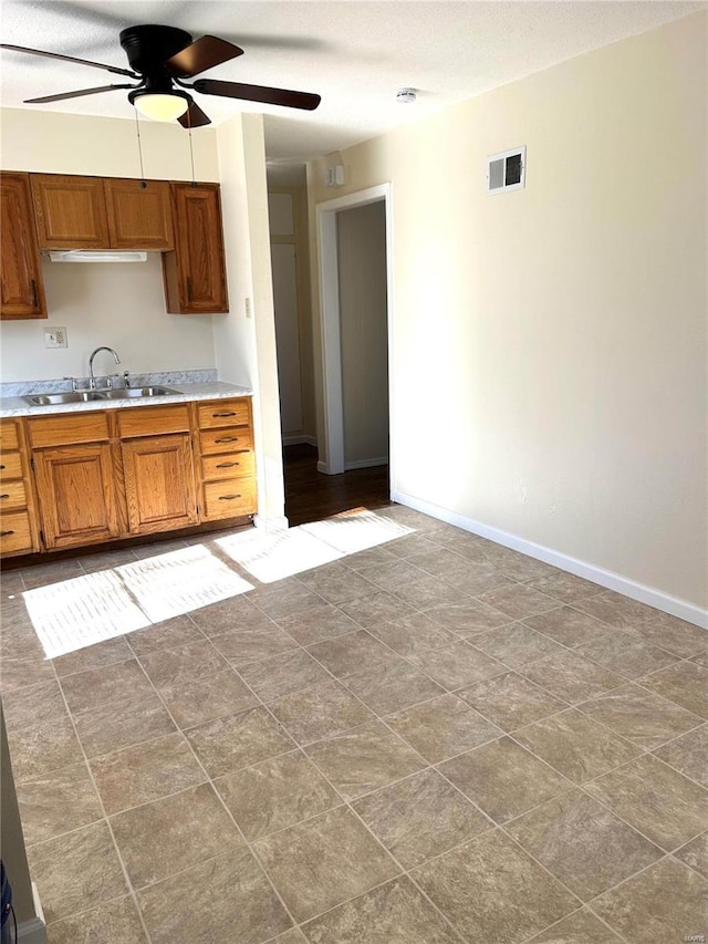 kitchen featuring ceiling fan and sink