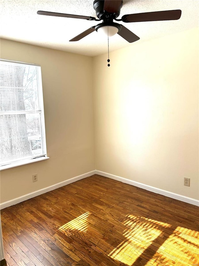 empty room featuring a textured ceiling, dark hardwood / wood-style floors, and ceiling fan