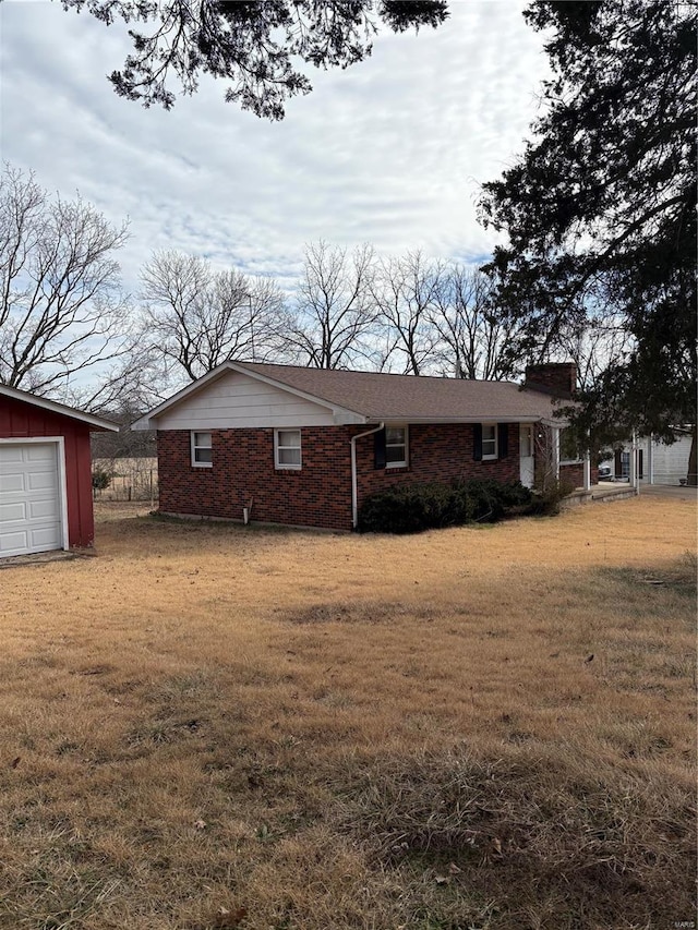 view of property exterior featuring a garage, a yard, and brick siding