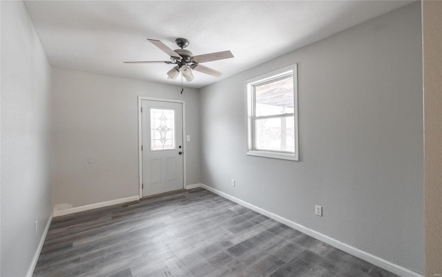 unfurnished room with ceiling fan, dark wood-type flooring, and a wealth of natural light