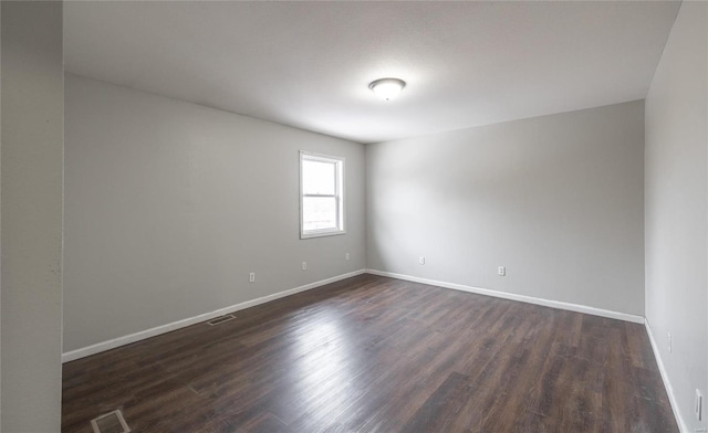 empty room with dark hardwood / wood-style flooring