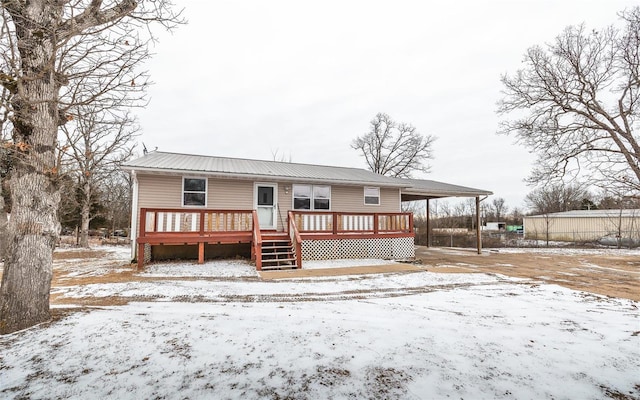 snow covered rear of property featuring a wooden deck