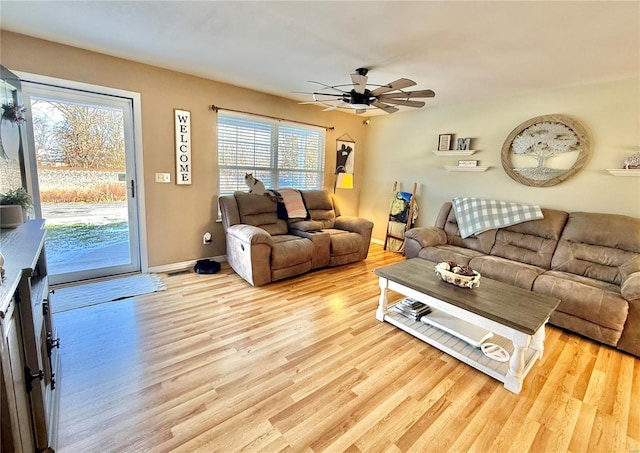 living room featuring ceiling fan, a wealth of natural light, and light hardwood / wood-style floors