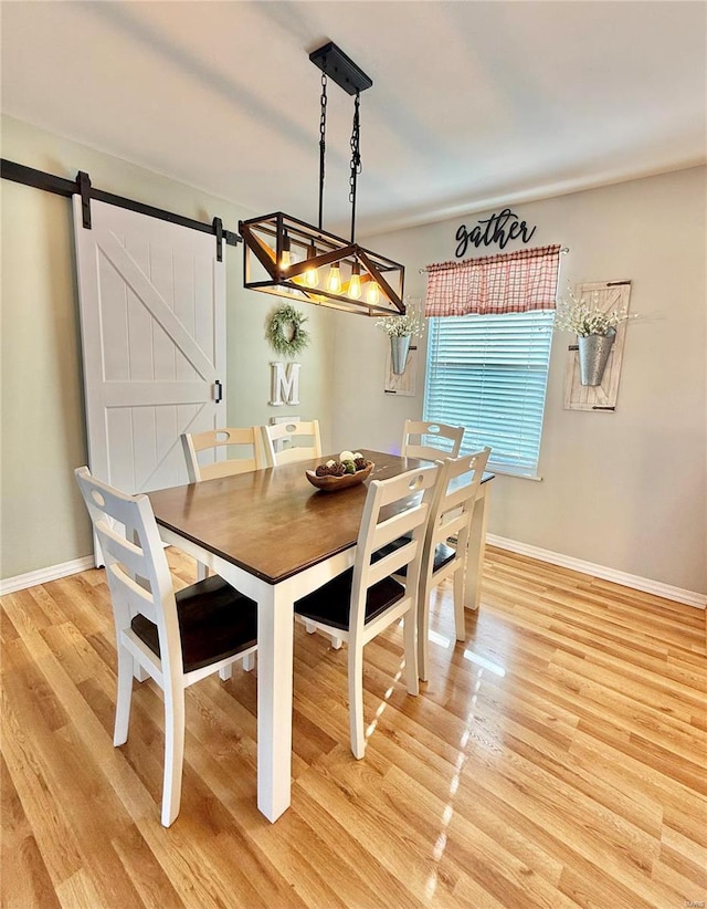 dining room with wood-type flooring and a barn door