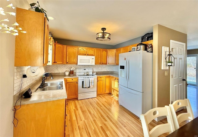 kitchen with sink, light wood-type flooring, white appliances, and backsplash