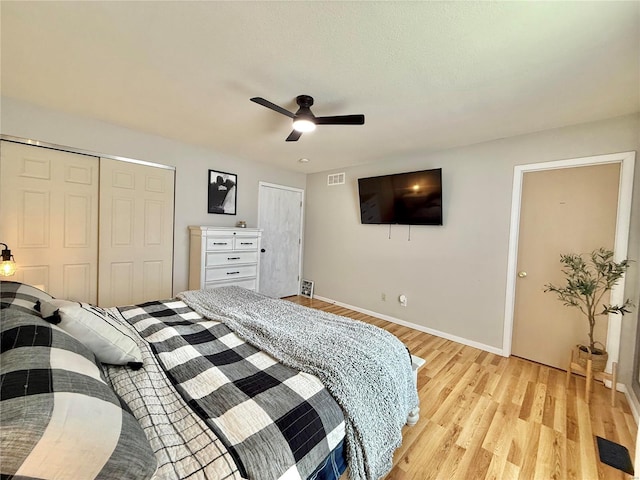 bedroom with ceiling fan, light hardwood / wood-style flooring, and a closet