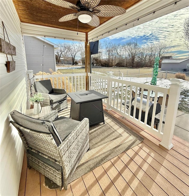 deck with ceiling fan and an outdoor living space