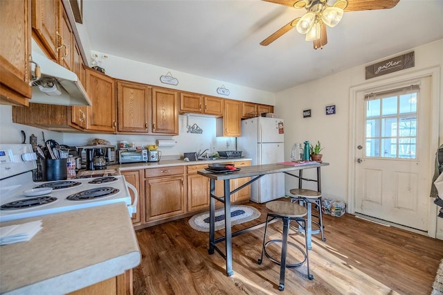 kitchen featuring ceiling fan, dark wood-type flooring, white appliances, and sink