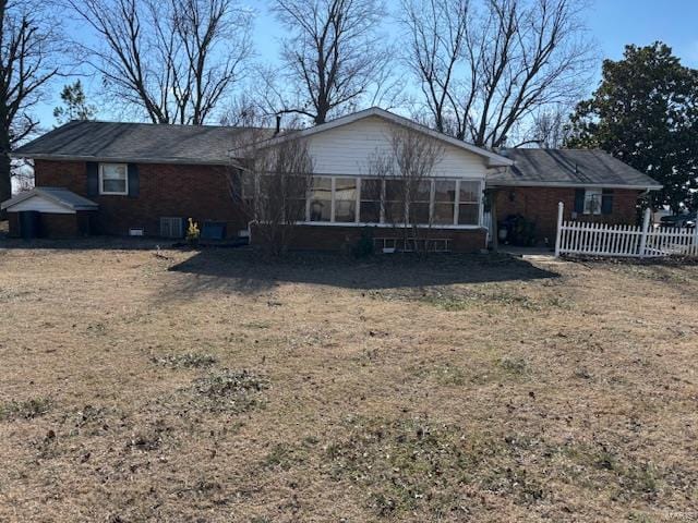 back of house with a lawn and a sunroom