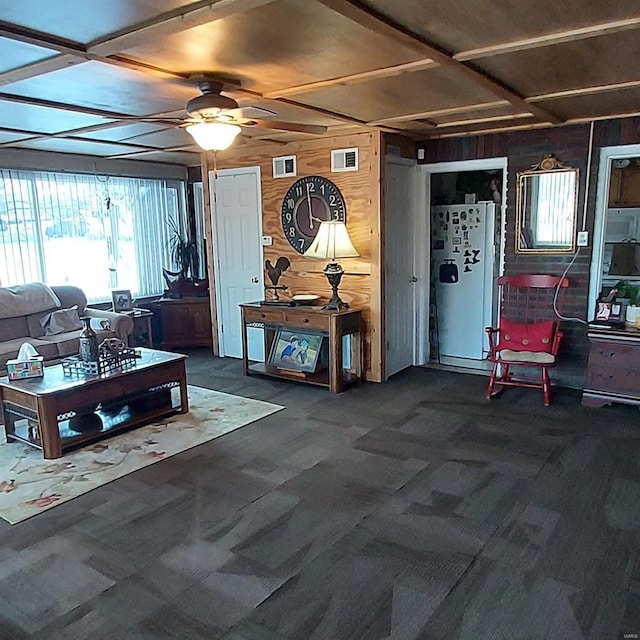 living room with ceiling fan and wood walls