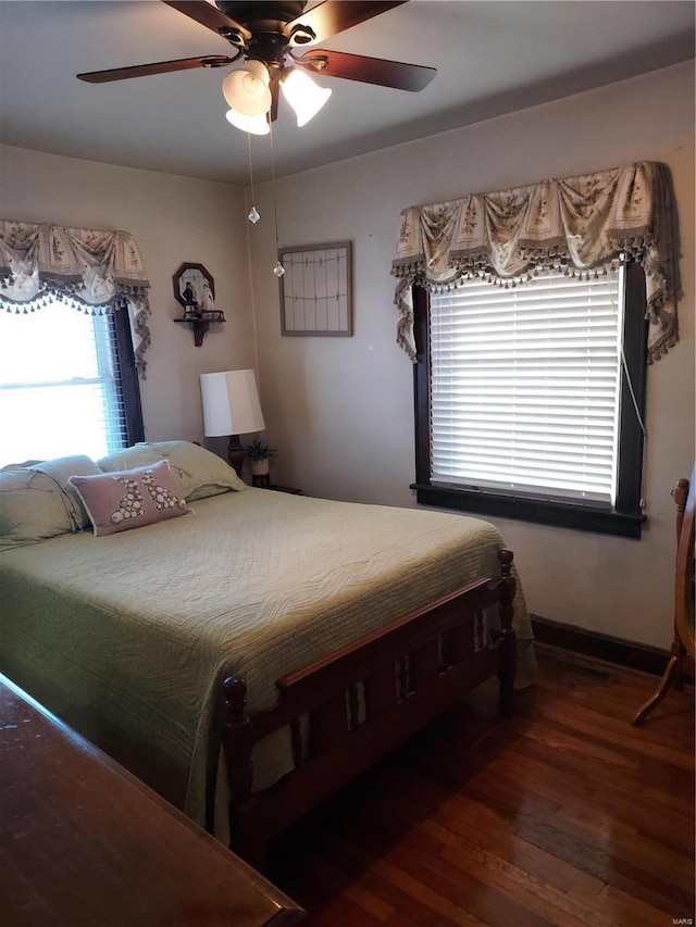 bedroom with dark hardwood / wood-style flooring and ceiling fan