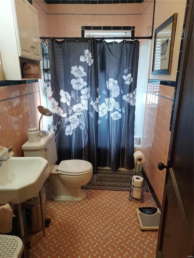 bathroom with tile walls, toilet, and a shower with shower curtain