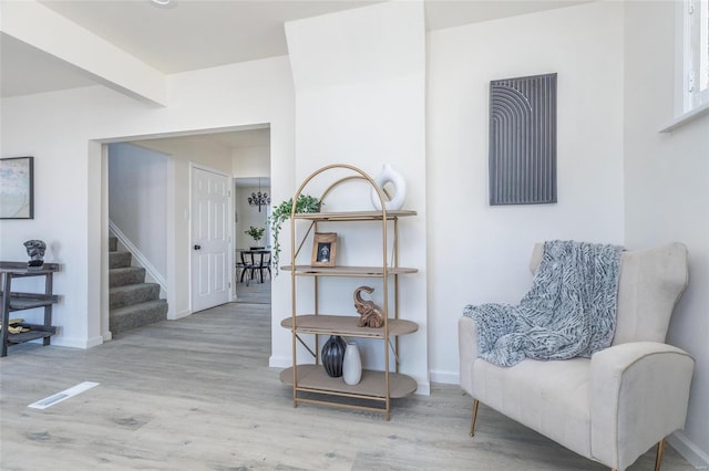 living area with light wood-type flooring and beam ceiling