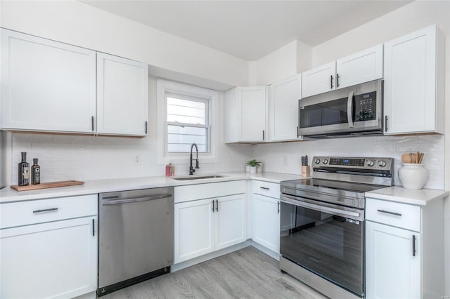 kitchen featuring sink, stainless steel appliances, white cabinets, and tasteful backsplash