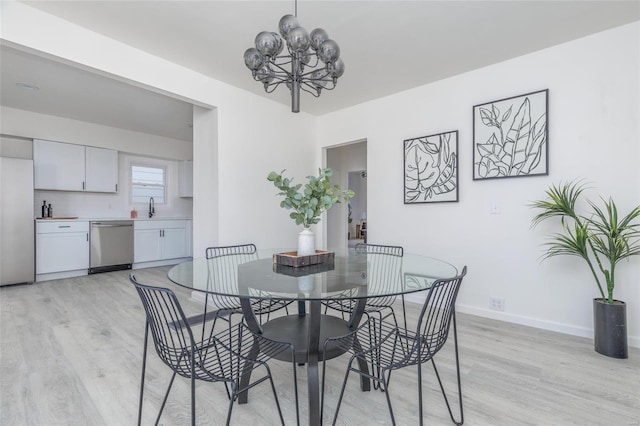 dining space featuring a notable chandelier, light hardwood / wood-style floors, and sink