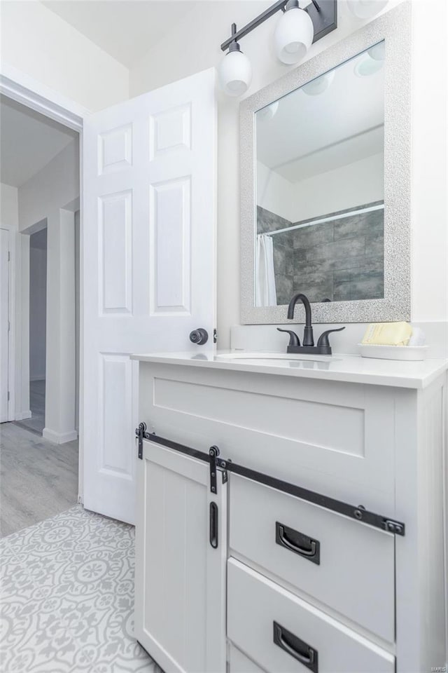 bathroom with vanity, curtained shower, and wood-type flooring