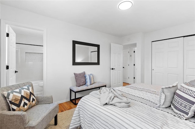 bedroom with a closet, ensuite bathroom, and light hardwood / wood-style flooring