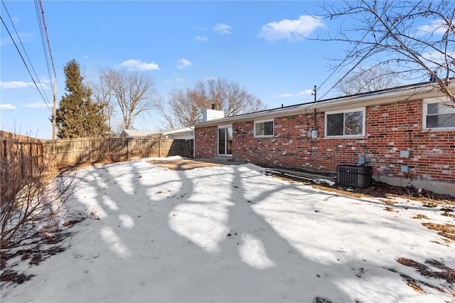 snow covered property with a patio and central AC