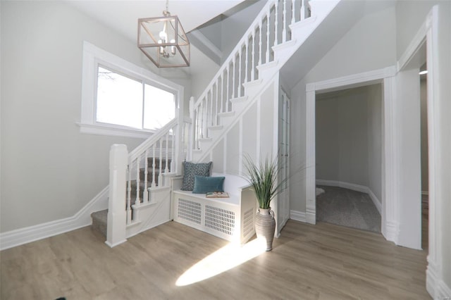 staircase with hardwood / wood-style flooring and a chandelier