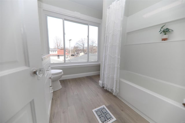 full bathroom featuring wood-type flooring, shower / bath combo with shower curtain, toilet, and vanity