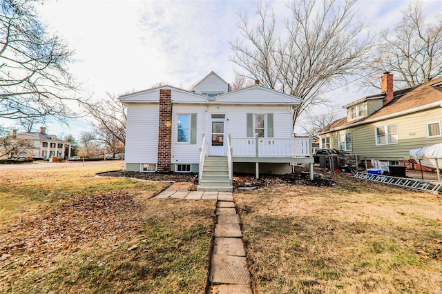 view of front facade featuring a front yard and a wooden deck