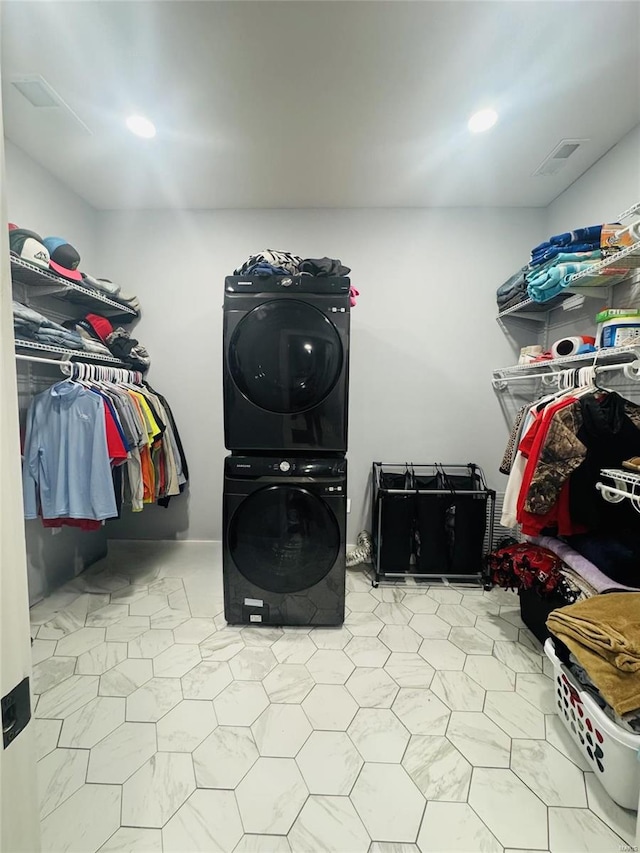 washroom featuring stacked washer and clothes dryer