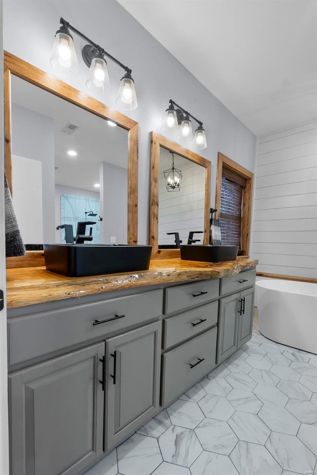 bathroom with vanity and a washtub