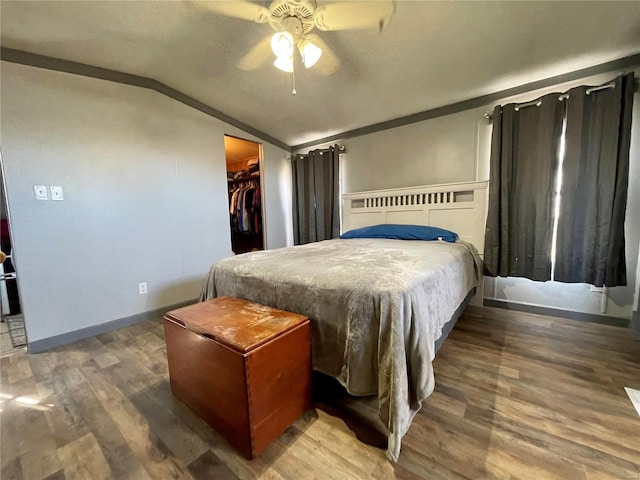 bedroom featuring a spacious closet, hardwood / wood-style floors, a closet, ceiling fan, and lofted ceiling