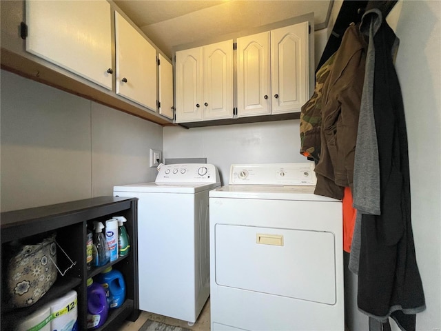 laundry area with washing machine and clothes dryer and cabinets