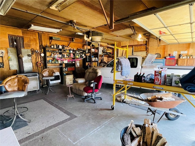 garage featuring wood walls and a workshop area