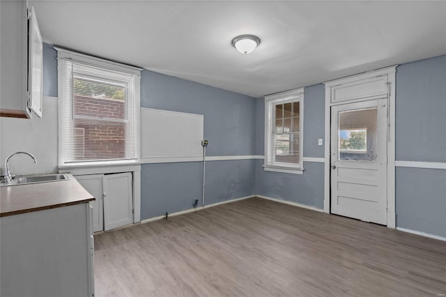 kitchen featuring sink, white cabinets, and light wood-type flooring